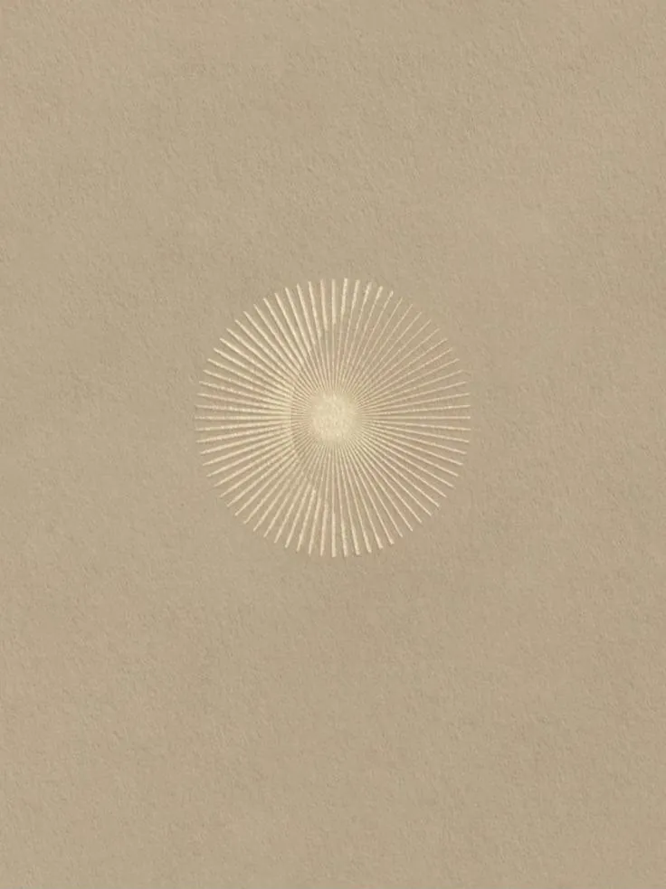 A gold sunburst pressed into warm paper